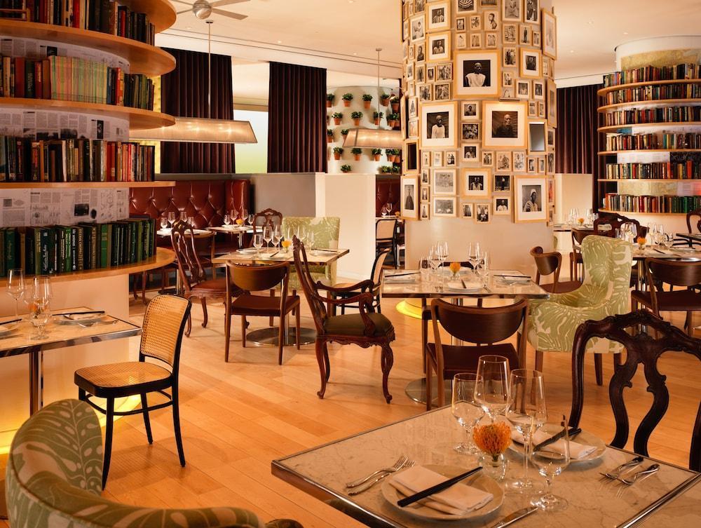 St Martins Lane London Hotel Kültér fotó The photo depicts an elegant restaurant interior with a modern and inviting atmosphere. The space features a combination of wooden flooring and stylish furniture, including uniquely designed chairs and tables. There are bookshelves lining the walls, 
