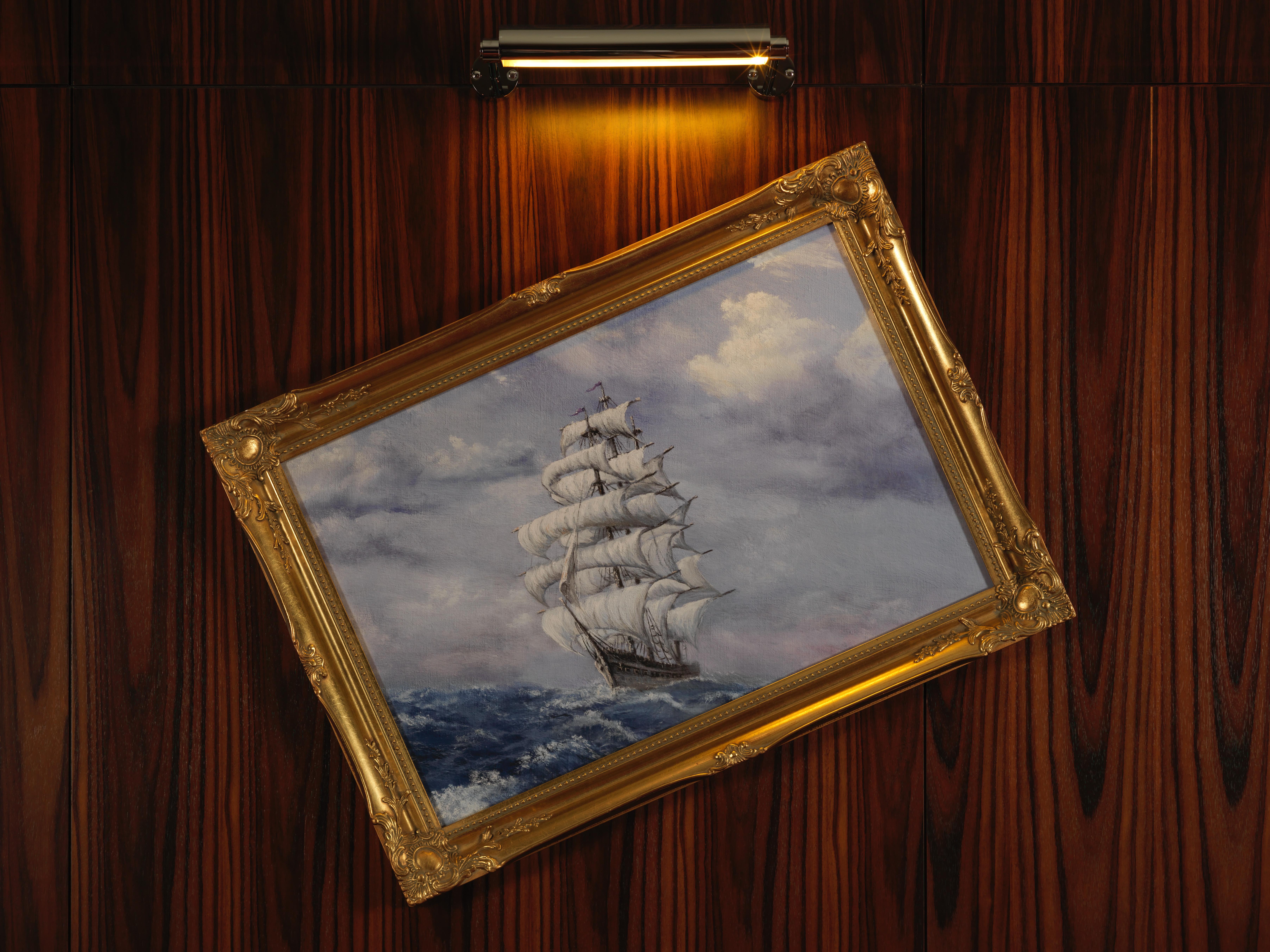 St Martins Lane London Hotel Kültér fotó The image depicts a painting of a sailing ship with multiple white sails, navigating through turbulent blue waters. The sky above is filled with clouds, adding to the overall dramatic effect of the scene. The painting is housed in an ornate golden fr