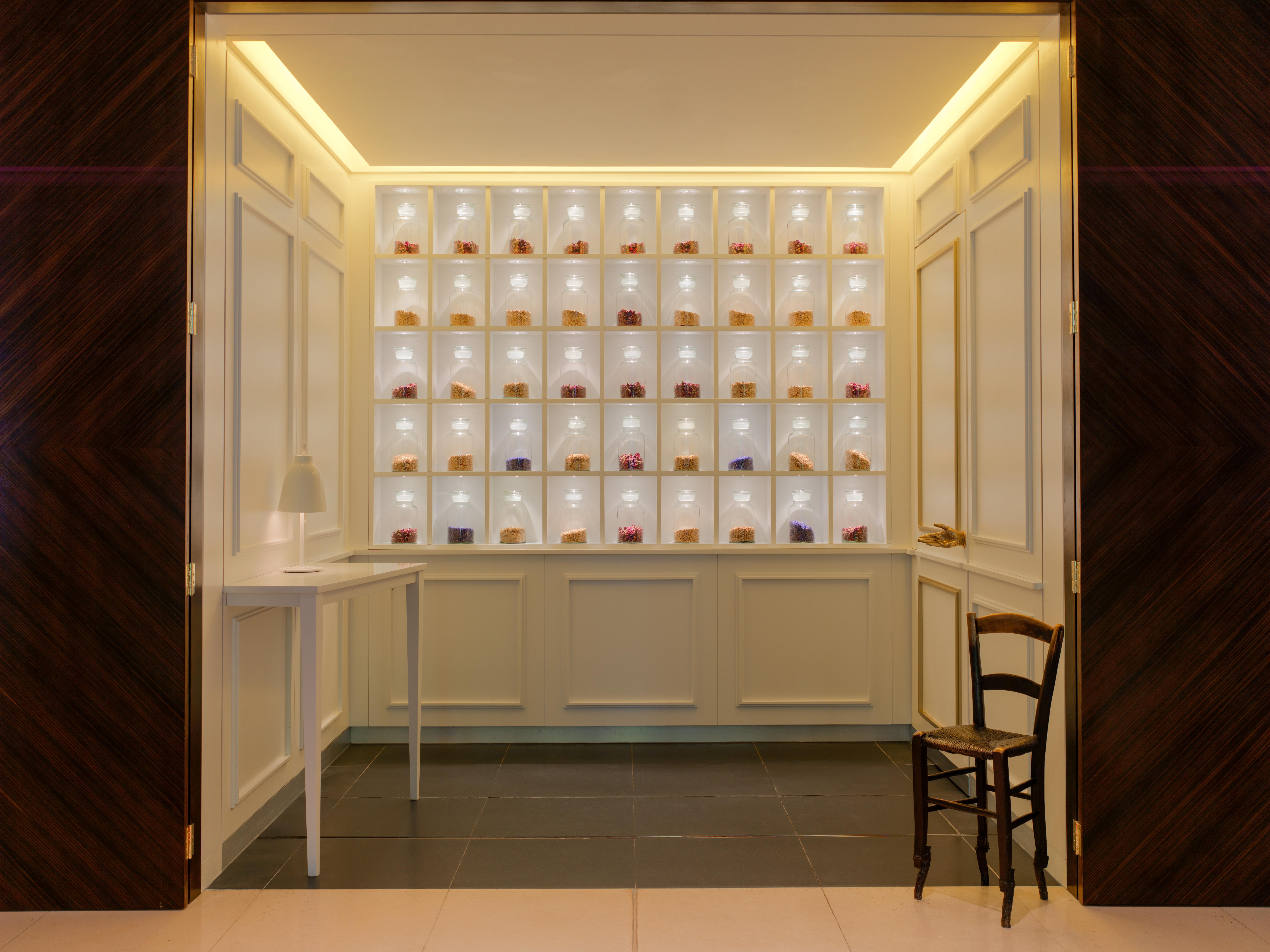 St Martins Lane London Hotel Kültér fotó The photo shows an elegant interior space that features a display wall with multiple shelves. Each shelf is illuminated, showcasing a variety of small items, likely decorative or artisanal products. The wall is light-colored, creating a bright atmosp