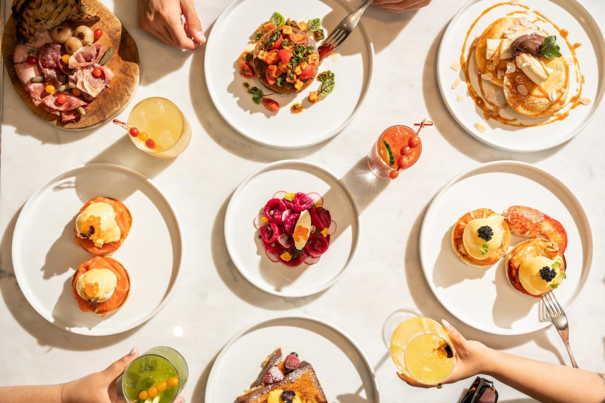 St Martins Lane London Hotel Kültér fotó The photo showcases a vibrant spread of food arranged on a table. There are several white plates displaying a variety of dishes. 

1. **Savory Dishes**: One plate features a colorful salad with tomatoes and greens. Another looks like a decadent dish,